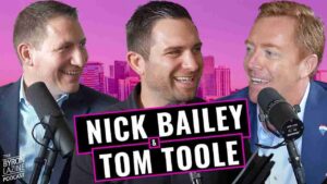 Three men in suits with studio mics podcasting, pink cityscape background and bold title Nick Bailey & Tom Toole