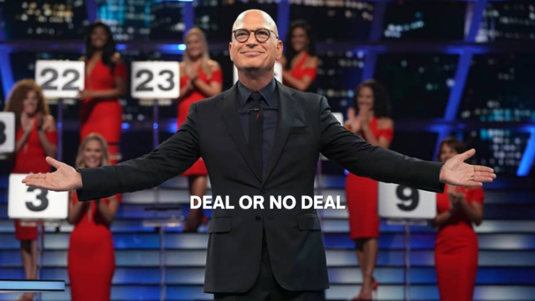Host in a black suit with arms outstretched on the Deal or No Deal set, contestants in red dresses holding number boards behind him.