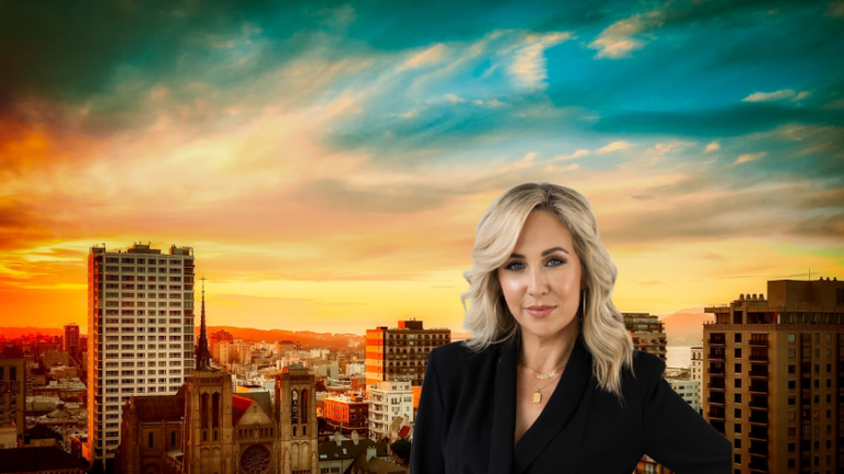 Professional woman with blonde hair in a black blazer stands against a city skyline at sunset, conveying a confident, corporate vibe.