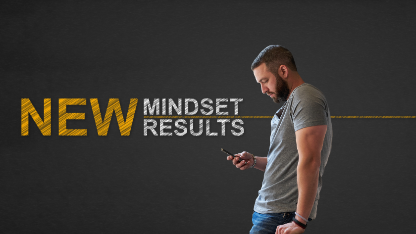 Man in a gray t-shirt looking at his phone beside bold text reading 'NEW MINDSET RESULTS' on a dark background.