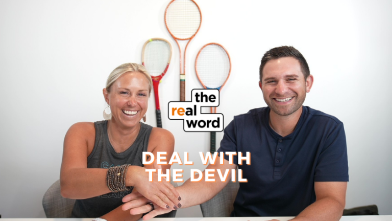 Two smiling hosts sit at a table with four tennis rackets on the wall behind them; podcast banner shows 'the real word' and the episode title 'DEAL WITH THE DEVIL'.
