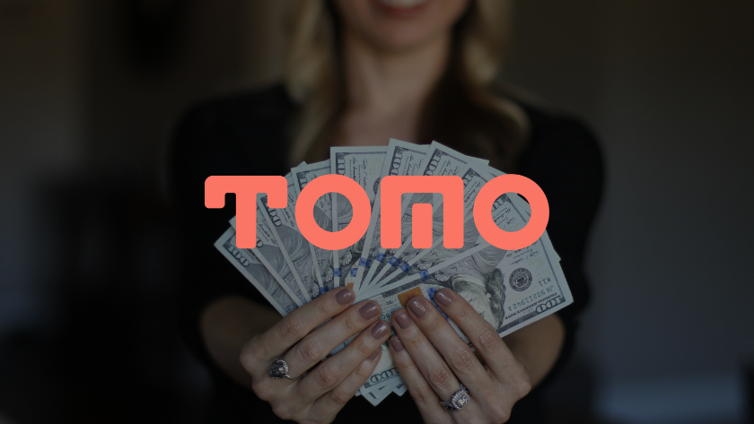 Woman holding a fan of US dollar bills with a pink TOPQ logo overlaid