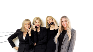 Four professional women in business attire pose together, each holding a corded telephone handset with spiraled cords visible on the left side.