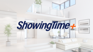 Bright, modern living room lobby with white furniture and glass railing, featuring the ShowingTime+ logo overlay.