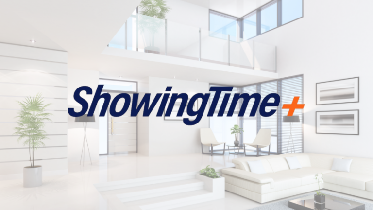 Bright, modern living room lobby with white furniture and glass railing, featuring the ShowingTime+ logo overlay.