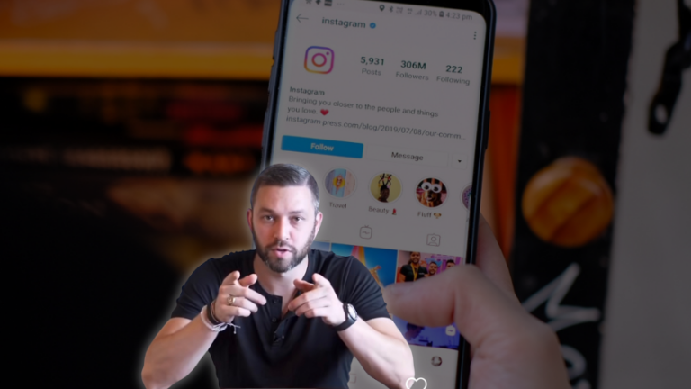 Bearded man pointing at the camera with a large smartphone screen behind him showing an Instagram profile