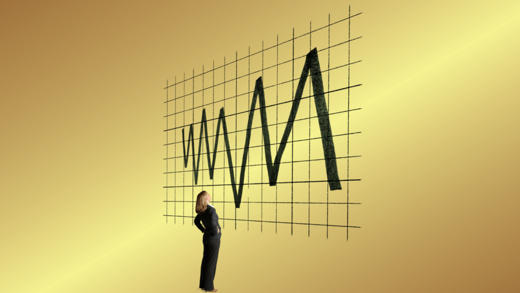 Businesswoman studying a large jagged line chart on a grid wall, symbolizing market volatility.