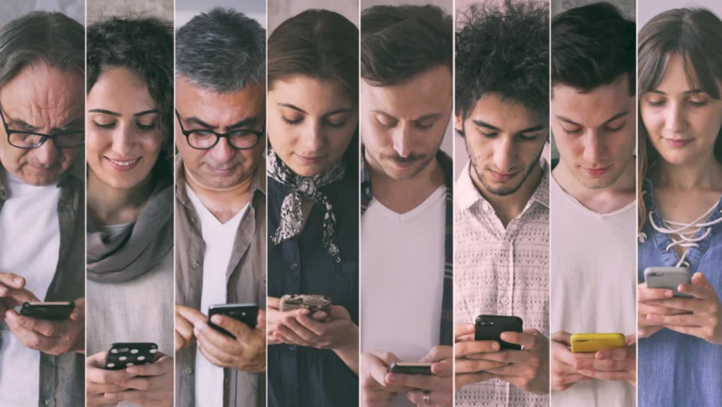 Eight diverse people standing in a row, each focused on a smartphone, illustrating group mobile device use.