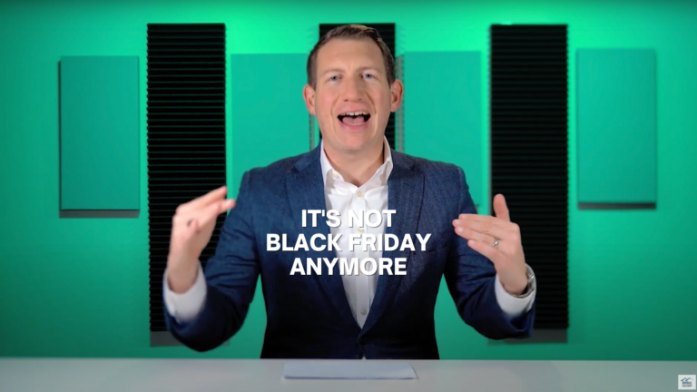 Man in a blue blazer sits at a desk in a green sound studio; bold white text reads 'IT'S NOT BLACK FRIDAY ANYMORE' overlayed on the image
