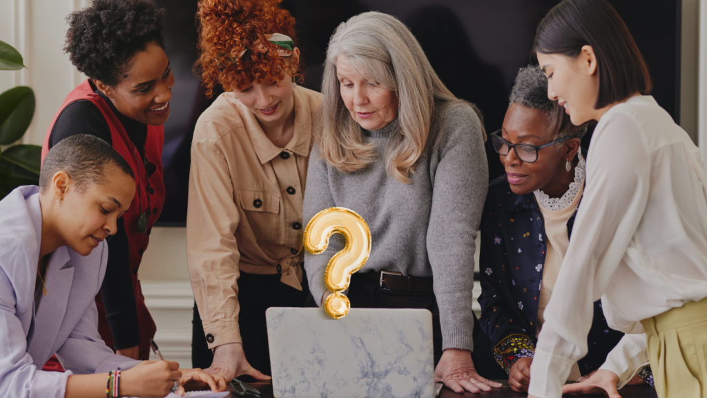 Diverse group of women around a laptop, focused on solving a problem, with a gold question mark rising from the screen.