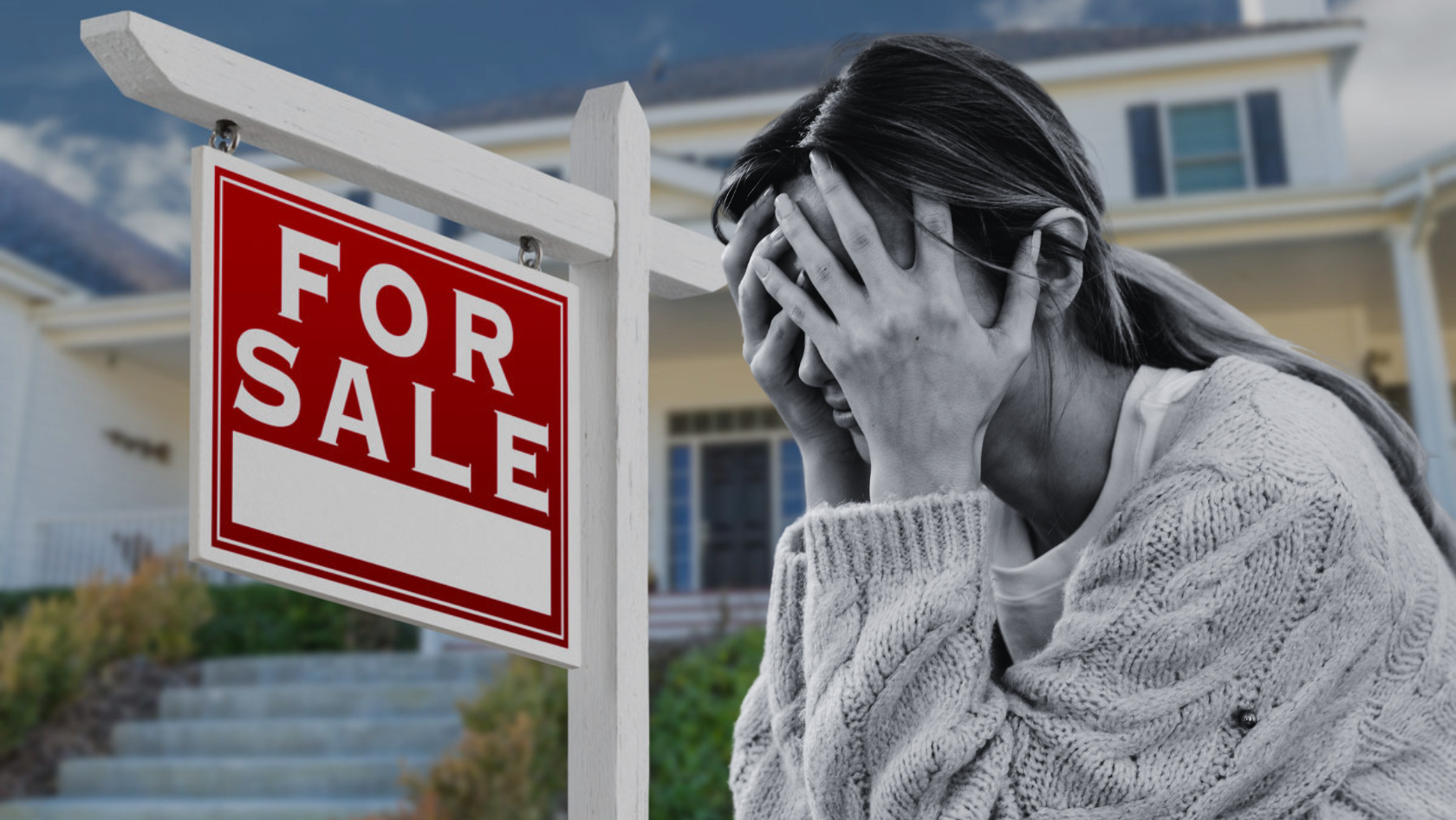 Woman holding her head in distress beside a large 'For Sale' sign outside a house yard.
