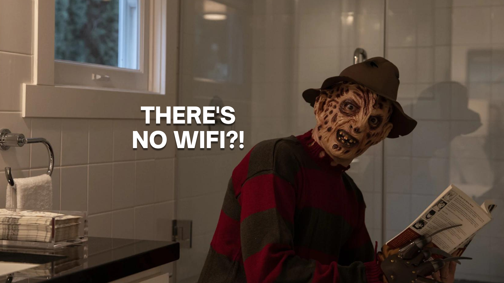 Masked horror figure in a red-and-gray striped sweater and brown hat stands in a bathroom, reading a magazine while a bold 'THERE'S NO WIFI?!' caption overlays the scene.