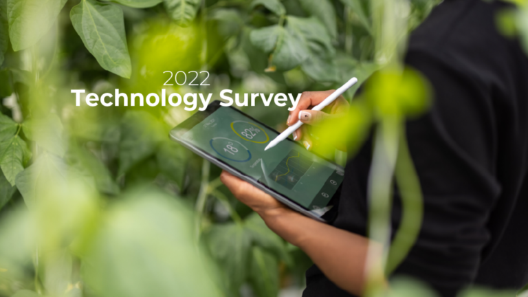 Person holding a tablet with a stylus outdoors among green leaves, displaying the '2022 Technology Survey' title.