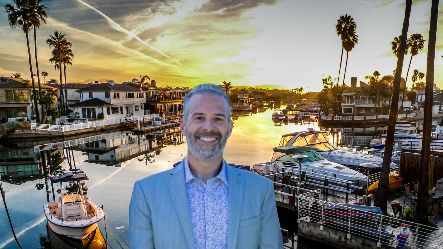 Smiling man in a blue blazer over a marina at sunset, with boats and palm trees in the background, as a cutout image.