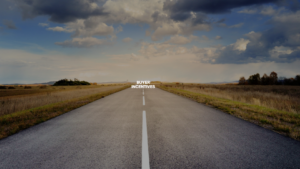 Open highway stretching to the horizon under dramatic clouds with the words 'BUYER INCENTIVES' centered on the road surface.