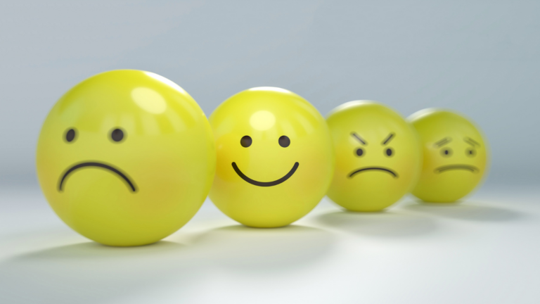 Four glossy yellow emoji balls in a row showing different emotions: sad, happy, angry, and worried.