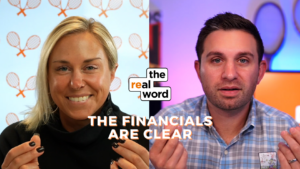 Split-screen shows a smiling woman on the left and a man speaking on the right, with the 'the real word' logo centered and the caption 'THE FINANCIALS ARE CLEAR' at the bottom.