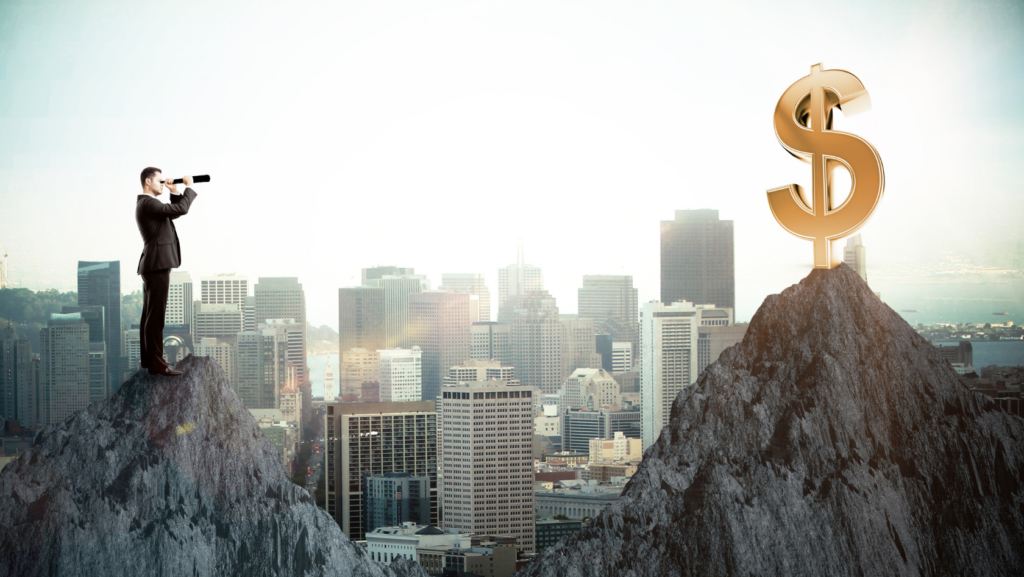 Businessman on a rocky peak aiming a telescope toward a giant golden dollar sign on another peak above a city skyline.