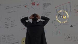 Back of a suited professional holding head in front of walls full of brainstorming diagrams, charts, and notes, signaling stress or planning (overlayed 'Free Webinar BAM' logo).