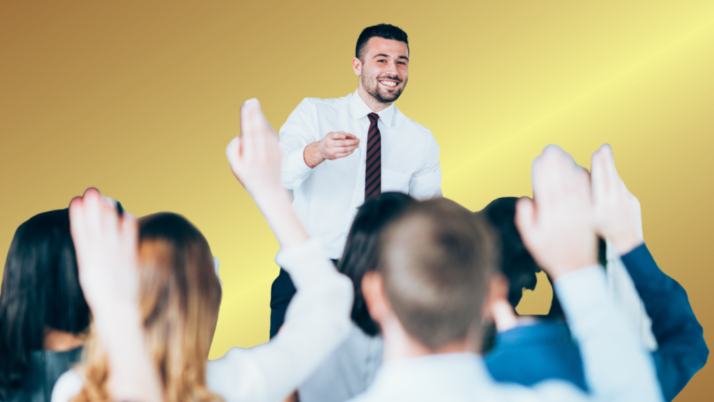 Speaker in a white shirt and striped tie high-fives a cheering crowd against a yellow gradient backdrop.