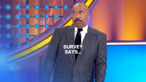 Man in a pinstripe suit on a bright game show set, with the text 'SURVEY SAYS...' overlaid.