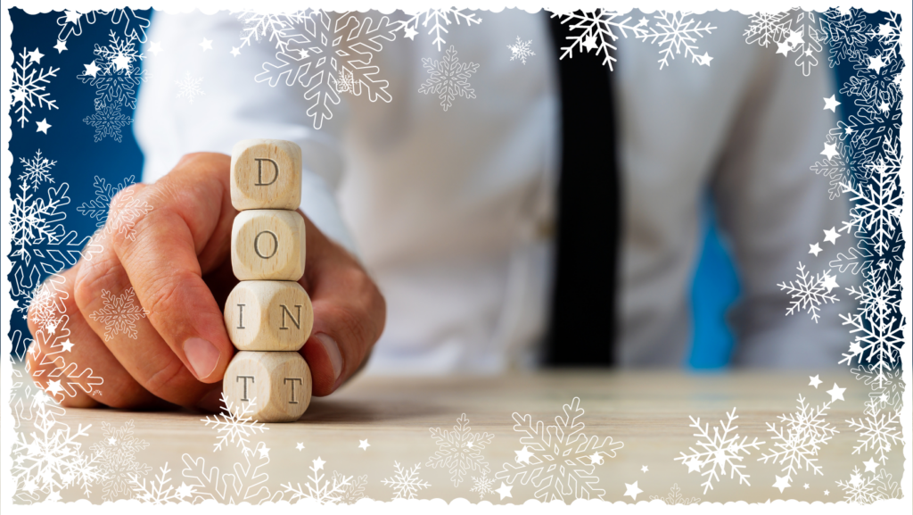 Close-up of a hand stacking wooden letter blocks spelling 'DOINT' on a desk, with a blurred suited figure in the background and a snowflake frame.