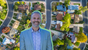 Aerial view of a suburban neighborhood with a smiling man in a blue suit overlaid in the foreground.