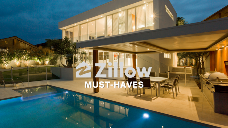 Modern two-story house with glass walls, a covered patio, and an illuminated rectangular pool at dusk outside a contemporary home.