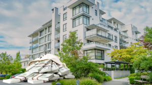 Modern white apartment building with glass balconies, greenery, and a large pile of cash in the foreground.