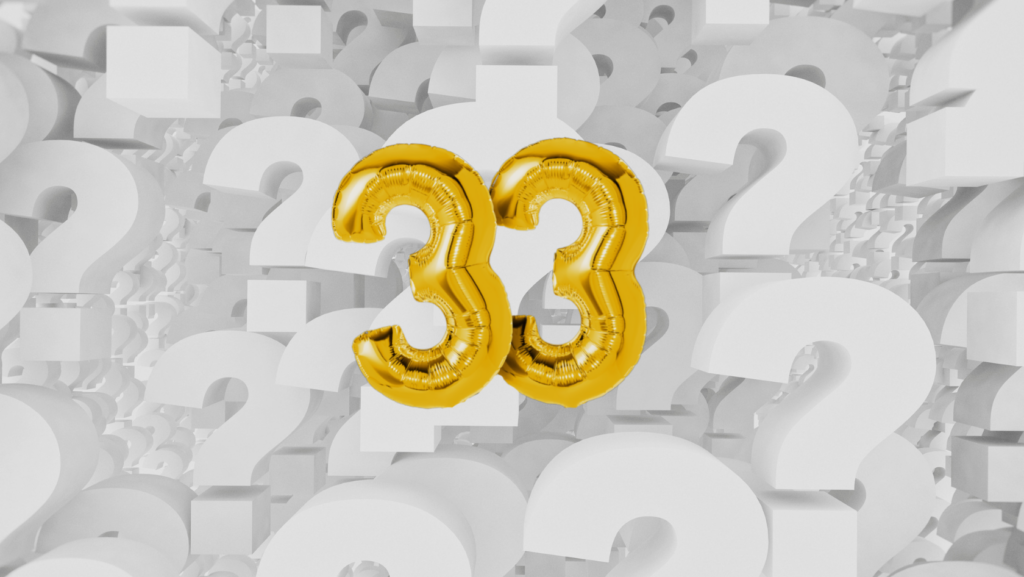 Two gold balloon 33s against a backdrop of white question marks in grayscale