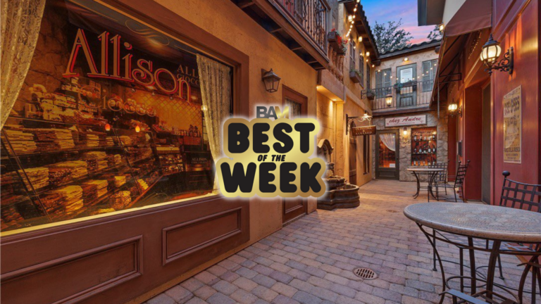 Warm-lit alley with shopfronts, outdoor tables, and a central 'BEST OF THE WEEK' badge overlay.