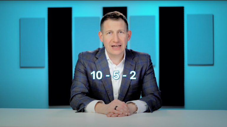 Male presenter in a blue checked blazer at a desk, with the math expression 10 − 5 − 2 on screen.