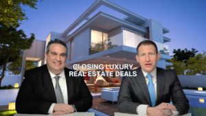 Two men in business attire sit at desks in front of a modern luxury home; title reads 'Closing Luxury Real Estate Deals'.
