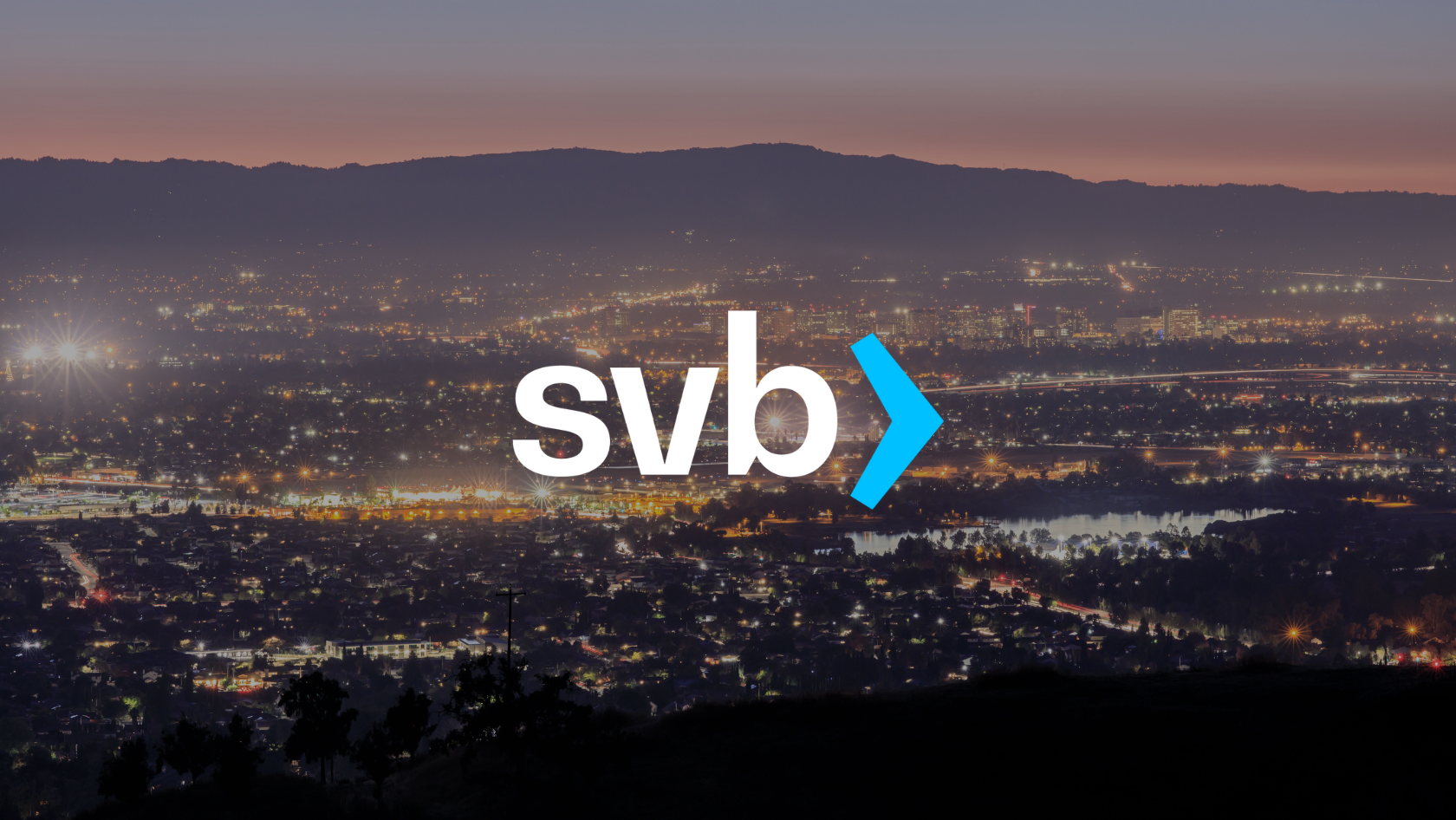 SVB logo centered over a cityscape at dusk, with a blue chevron to the right of the letters.