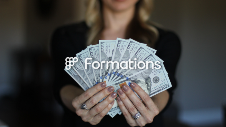 A person fanning out multiple hundred-dollar bills while holding them in front of their chest, with a white 'Formations' logo overlaid.