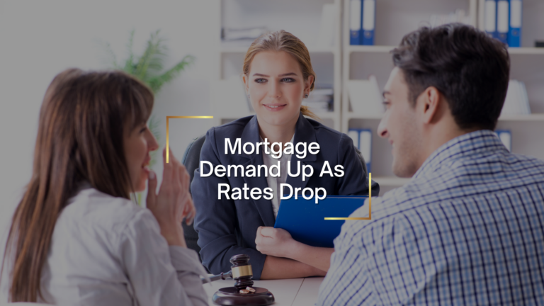 Three colleagues discuss mortgage news around a table, with a central woman in a blazer and a headline: Mortgage Demand Up As Rates Drop.