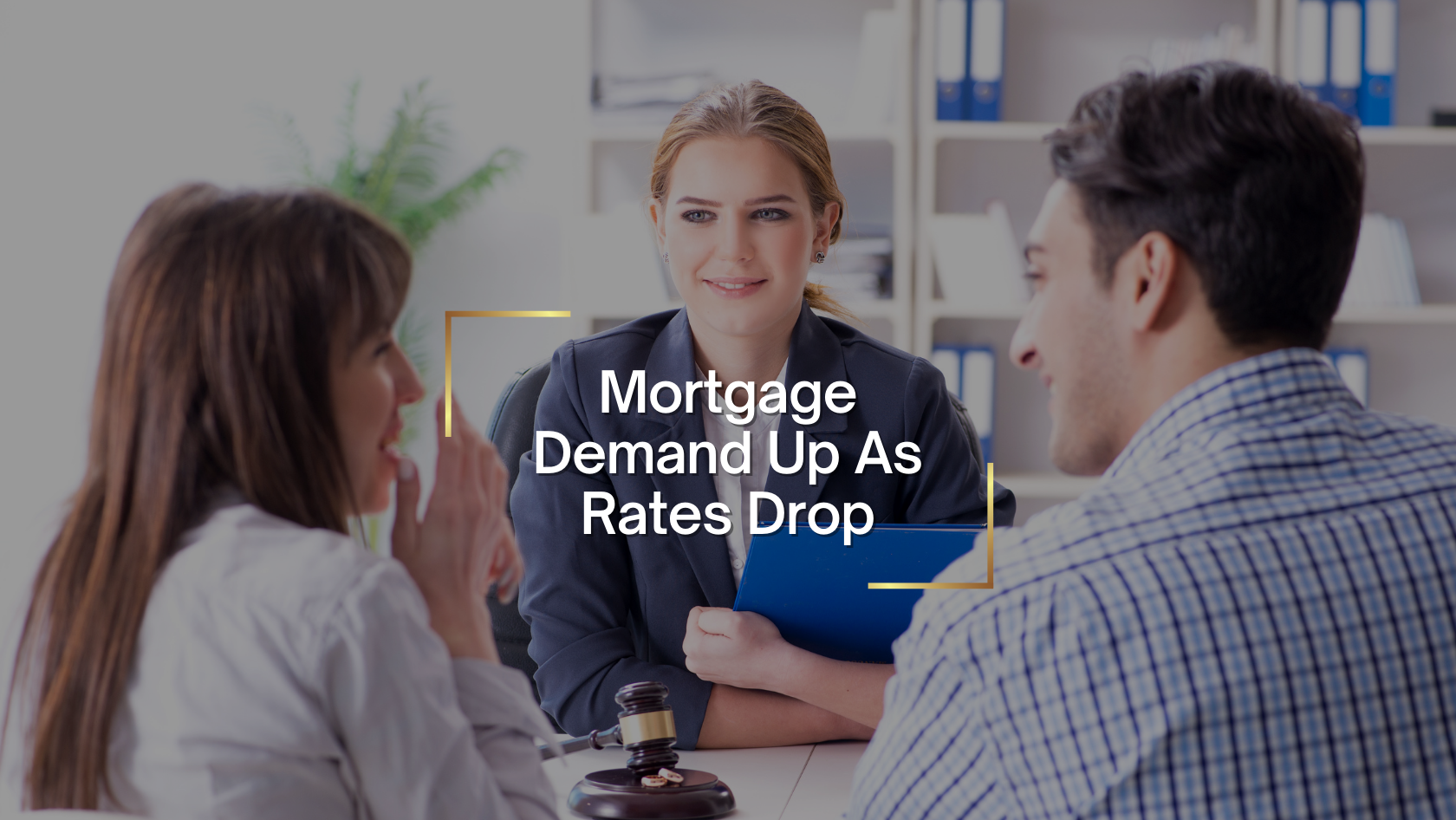 Three colleagues discuss mortgage news around a table, with a central woman in a blazer and a headline: Mortgage Demand Up As Rates Drop.