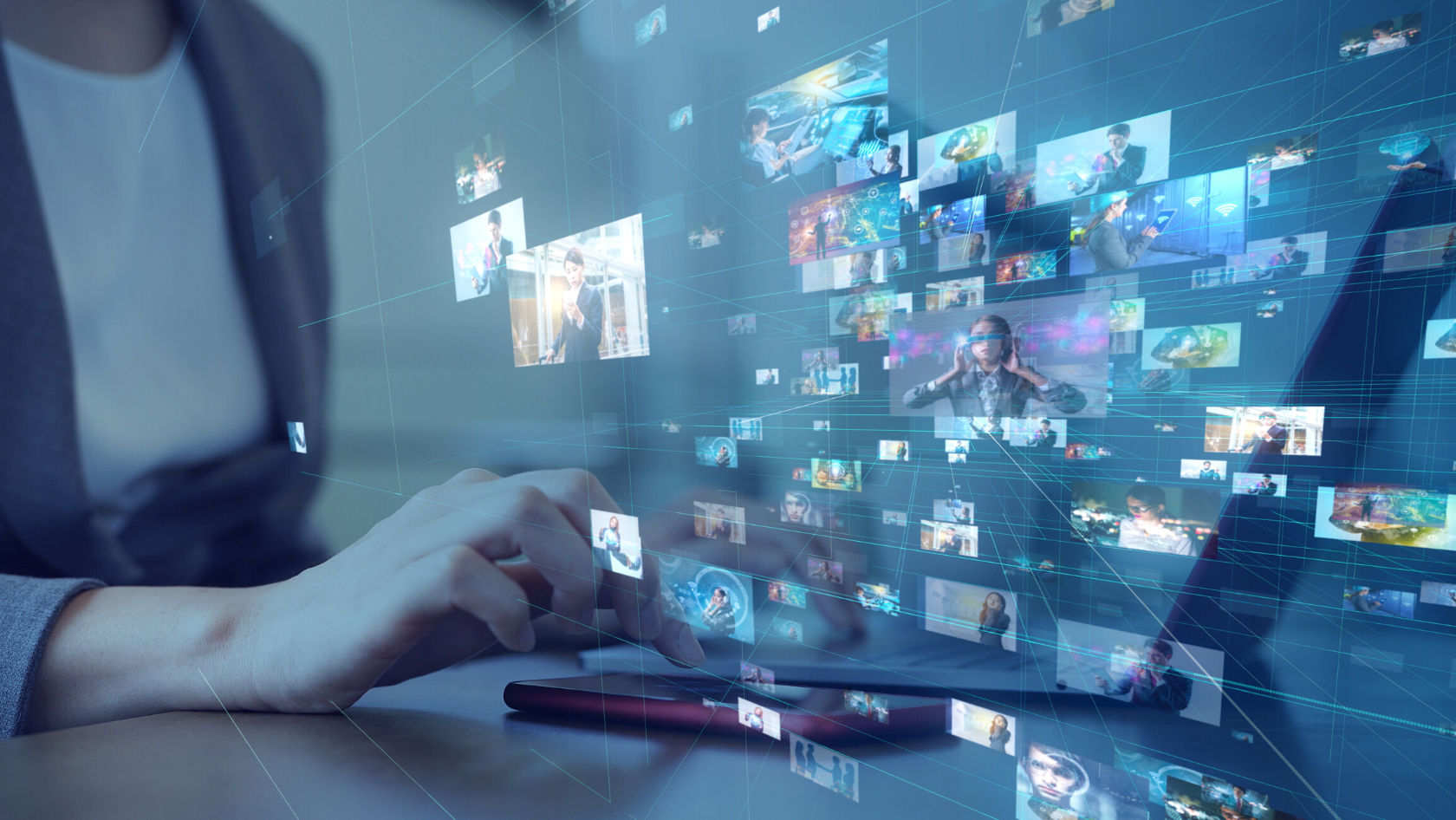A person typing at a desk with floating, interconnected thumbnail images representing digital media and networks behind them.