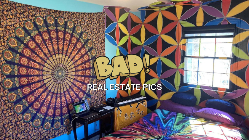 Bohemian bedroom with a mandala tapestry on the left wall, colorful geometric mural on the right, a window, keyboard on a small table, laptop, and a tie-dye bed with purple pillows.