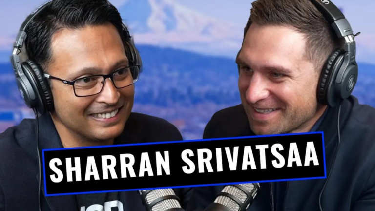 Two men wearing large over-ear headphones chat and smile during a podcast recording with microphones in front of them, a bold banner shows 'SHARRAN SRIVATSA' across the image.