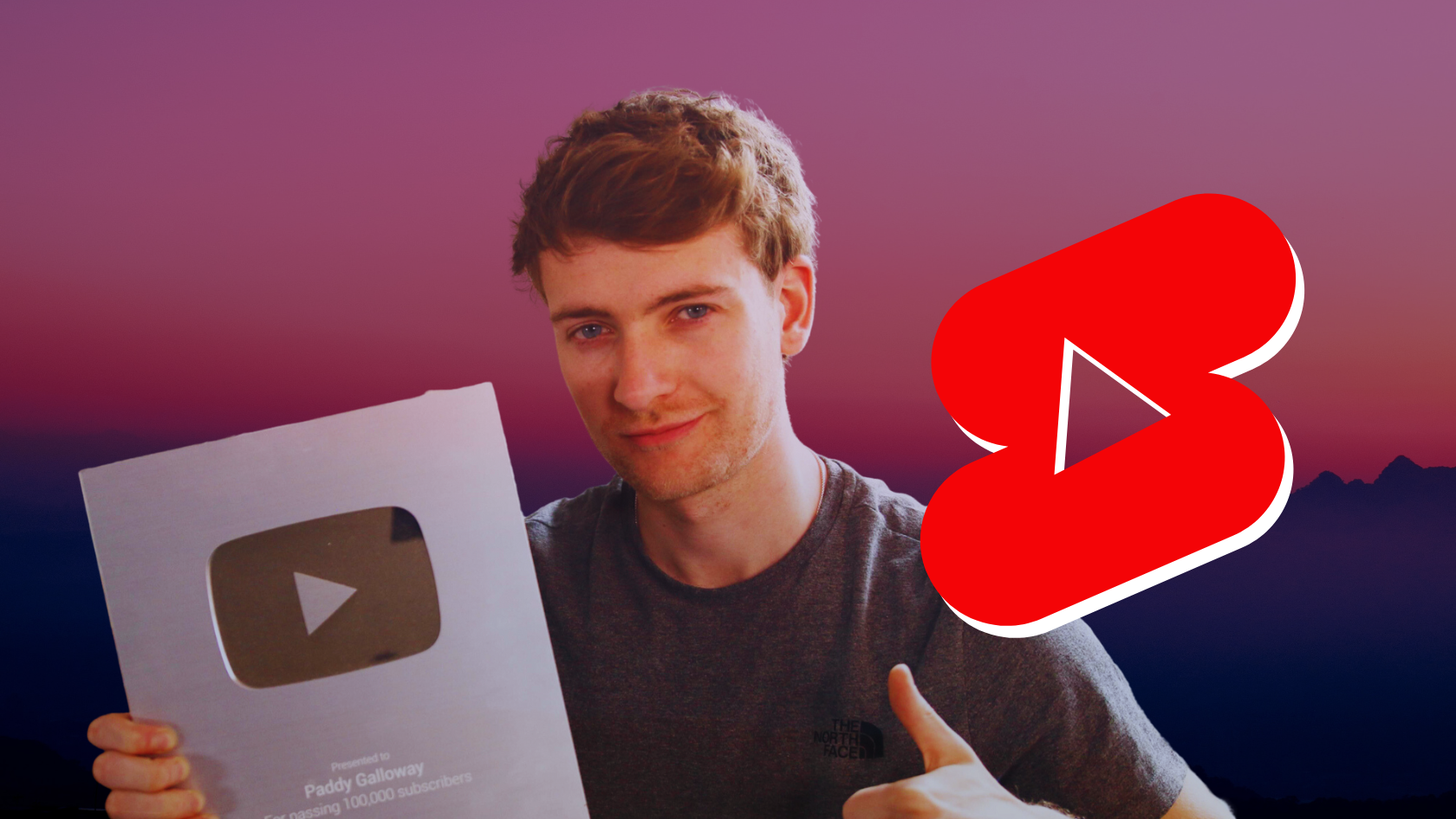 Man holding a silver YouTube Creator Award plaque and giving a thumbs up, with a large red play button graphic on the right over a sunset gradient background.