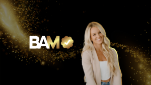 Bold 'BAM' logo with gold checkmark badge and a smiling blonde woman on a black and gold sparkling background, conveying success or approval marketing banner.