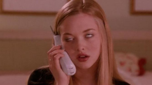 Woman with long blond hair on a landline phone, rolling her eyes as she speaks.