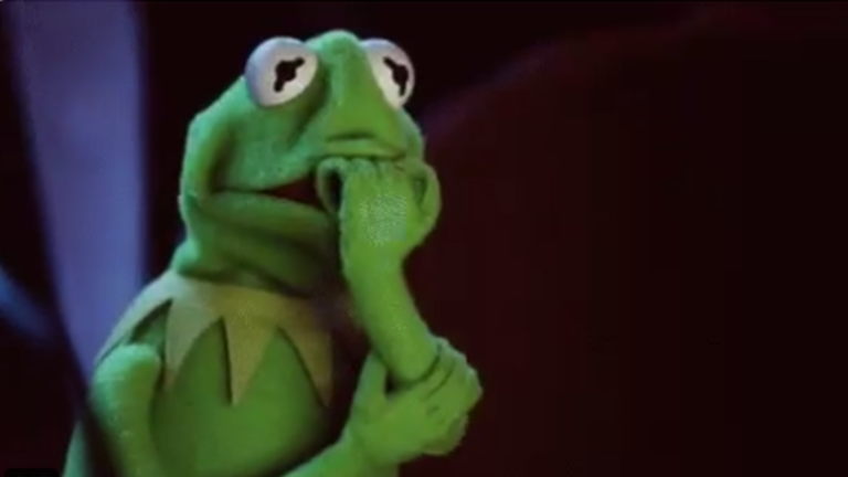 Kermit the Frog puppet with a thoughtful pose, hand resting on chin.