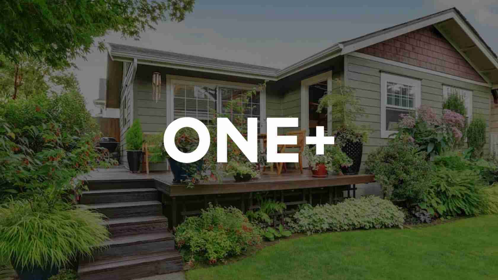 Home exterior with a wooden deck and abundant potted plants, featuring a large ONE+ overlay text on the center of the image. Divider line omitted for accessibility clarity.