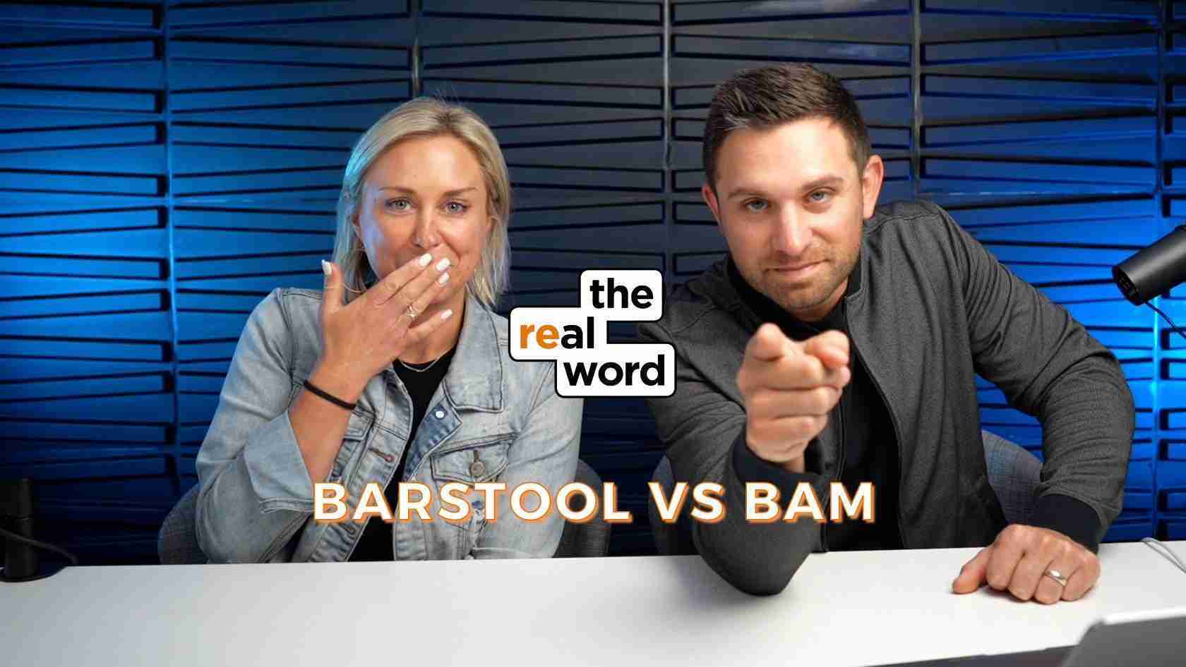 Two podcast hosts sit at a desk in a blue studio; the woman covers her mouth playfully, the man points at the camera, with the 'the real word' logo between them and 'BARSTOOL VS BAM' text below.