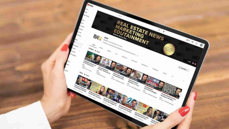 Person holding a tablet displaying a YouTube channel page titled Real Estate News Entertainment with video thumbnails aligned in rows.