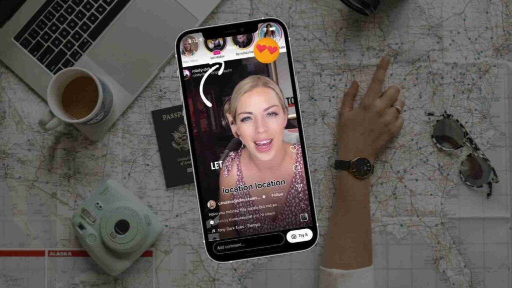 Smartphone livestreaming a woman against a map backdrop, surrounded by travel gear like a passport, camera, coffee mug, and laptop nearby.
