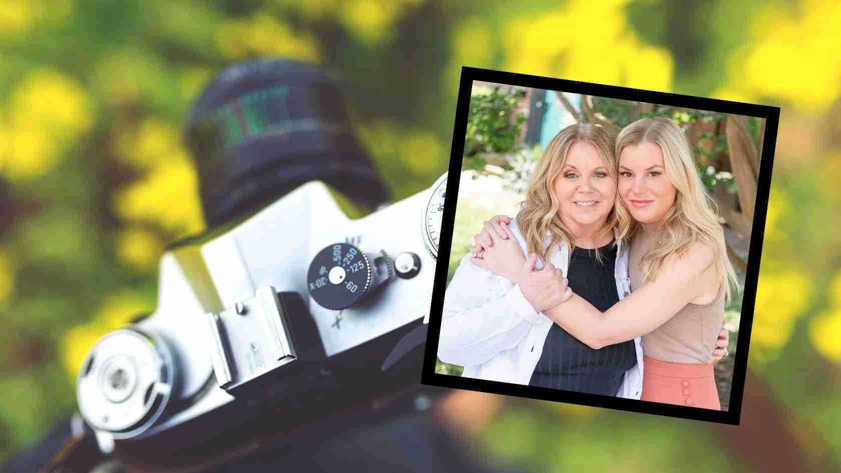 Framed photo of two women smiling and embracing, placed over a blurred vintage camera on a sunny green backdrop.
