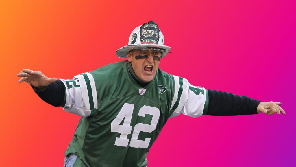 Football player in Jets jersey #42, arms outstretched, mouth open, against an orange–pink gradient background.